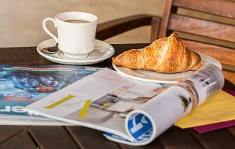 a cup of tea, a croissant and some magazines