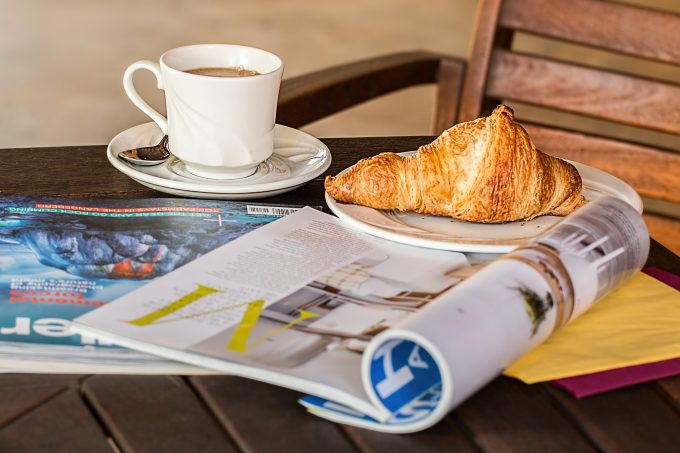 a cup of tea, a croissant and some magazines