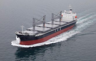 a large bulk carrier sailing towards the bottom left of the picture