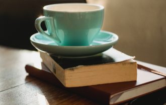 a green cup sits on a pile of books