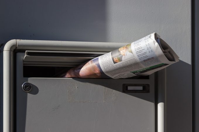 a newspaper poking through a letterbox 230731 morning