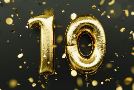 good ballons spell out 10 and gold confetti fills the picture against a black background