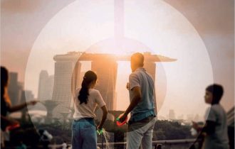 blurry view of a family in a park with Singapore's Marina Bay Sands hotel in the distance