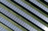 a view of rows of solar panels in a grassy field from above