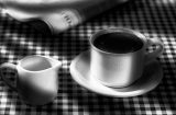 coffee cup and milk jug on chequered cloth in black and white
