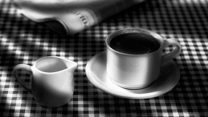 coffee cup and milk jug on chequered cloth in black and white