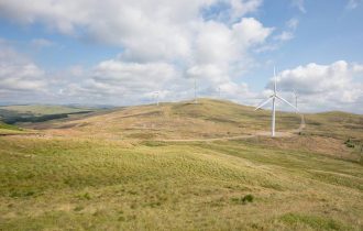 a wind farm on grass covered hill