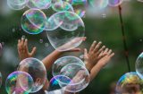 children bursting soap bubbles