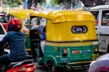yellow and green tuktuk in crowded traffic in Bengaluru