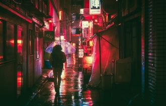 Osaka in the rain at night - person walking with an umbrella against neon lights