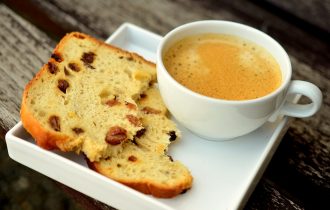 a cup of coffee and a slice of a fruit loaf