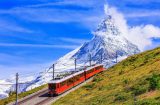 a train climbing a mountan against the backdrop of the matterhorn