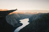 a man sitting on a ledge above a canyon