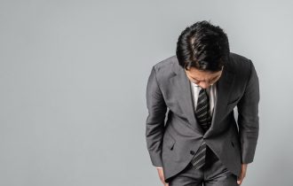 a japanese man bowing to the camera