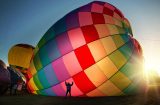 a multi-coloured hot air balloon being inflated