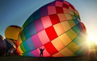 a multi-coloured hot air balloon being inflated