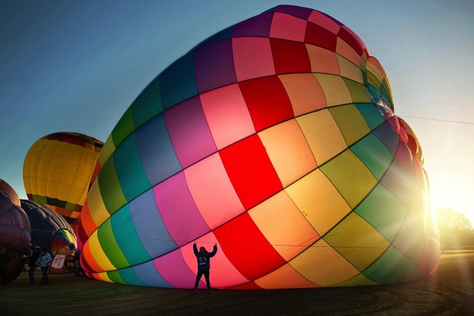 a multi-coloured hot air balloon being inflated