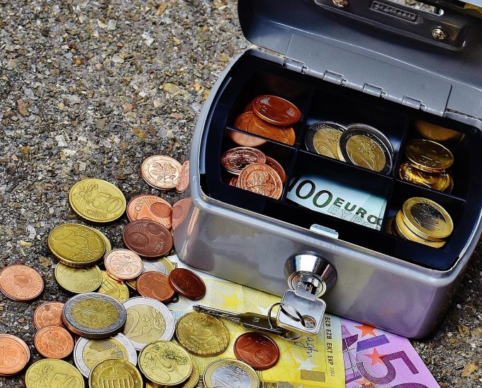 a cash box with euro coins and notes underneath
