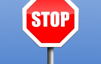 a red hexagonal stop sign against a blue sky