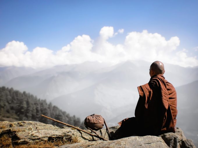 a monk looks out across a valley