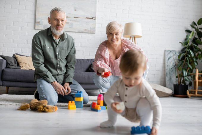 two grandparents and a baby playing with building blocks