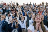 an excited crowd stares upward as Artemis 2 mission takes off