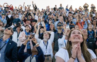 an excited crowd stares upward as Artemis 2 mission takes off