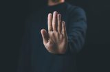 a man with his palm facing us indicating stop