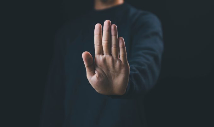 a man with his palm facing us indicating stop