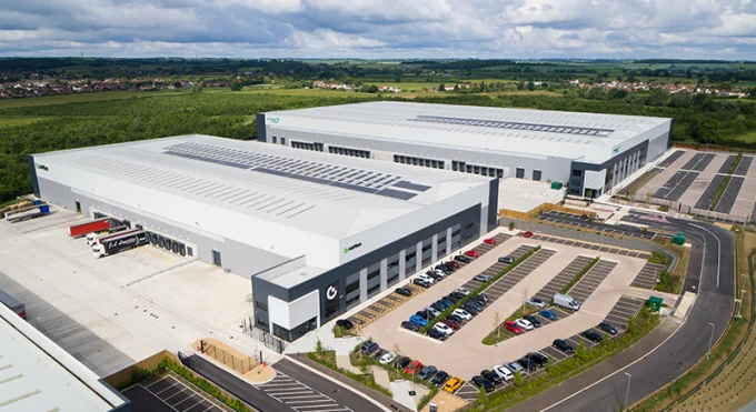 an aerial shot of lmp's beford logistics park - couple of sheds and a car park