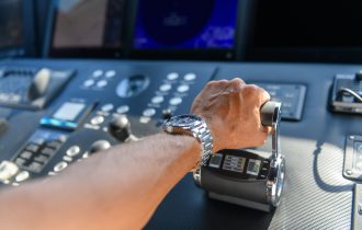 a close up view of a hand pushing on a throttle to make an engine (probably a boat) go faster