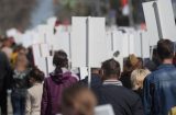 a group of protesters carrying placards seen from the back - no visible message
