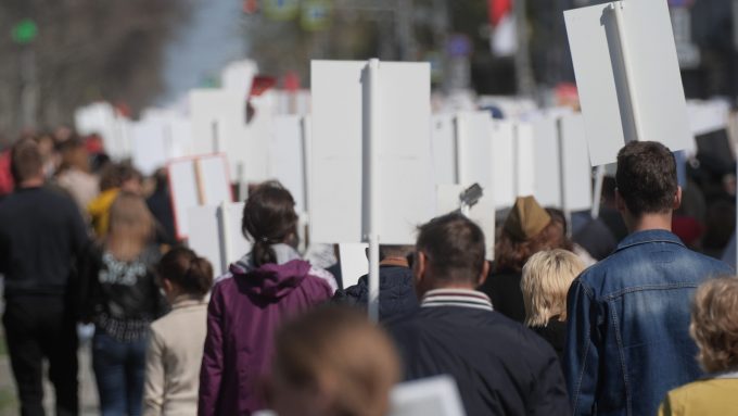 a group of protesters carrying placards seen from the back - no visible message